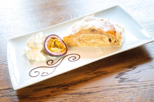 a white plate with food on a wooden table at Hotel Haus Delecke in Möhnesee