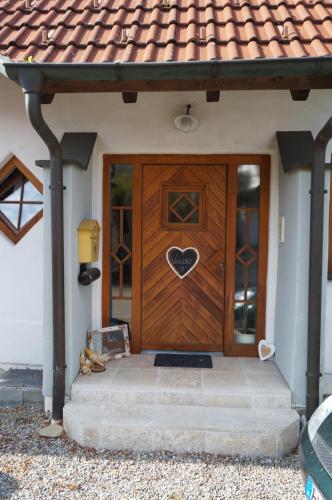 a house with a wooden door with a heart on it at Gemütliche Wohnung in Wolfegg - Das Tor zum Allgäu in Wolfegg