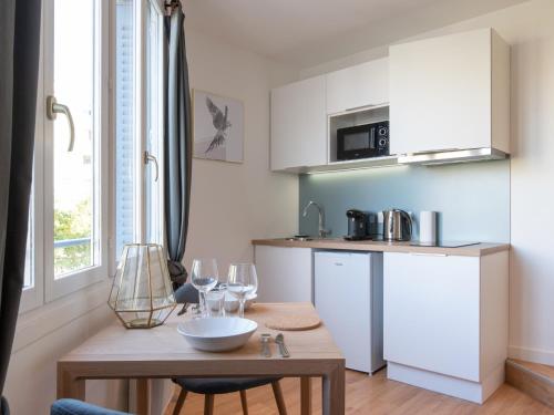 une cuisine avec une table avec des verres à vin dessus dans l'établissement Appartements Le Berliet - Montplaisir, à Lyon