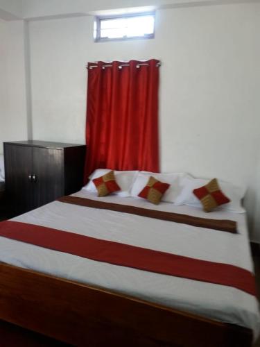 a bedroom with a large bed with a red curtain at Heritage Lodge in Cherrapunji