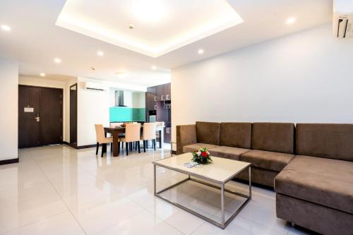 a living room with a couch and a table at Becamex Hotel New City in Thu Dau Mot