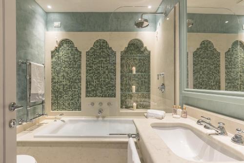 un bagno con una grande vasca e un grande specchio di Gondolieri Terrace- Dimora Italia Collection - a Venezia
