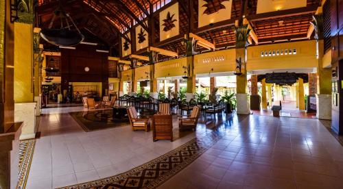 a lobby with tables and chairs in a building at Pandanus Resort in Mui Ne