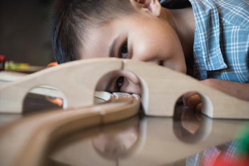 un jeune garçon se posant sur une table jouant avec un jouet dans l'établissement CGH Résidences & Spas Les Fermes de Ste Foy, à Sainte-Foy-Tarentaise