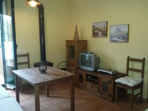 sala de estar con TV, mesa y sillas en Mirador de Jabuguillo, en Aracena