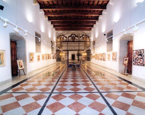 an empty gallery with a checkered floor in a museum at Parador de Santiago - Hostal Reis Catolicos in Santiago de Compostela