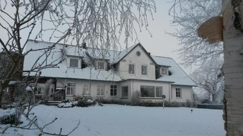 a white house with snow on the roof at Hansenhof in Kappeln