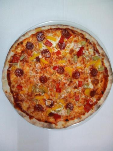 a pizza sitting on top of a white table at Payet Apartments in L'Estartit