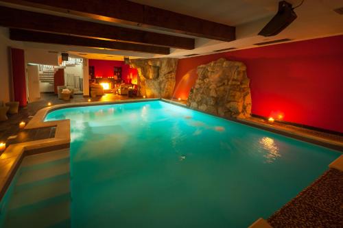a swimming pool in a house with a rock wall at Relais Ducale Spa & Pool in Pescocostanzo