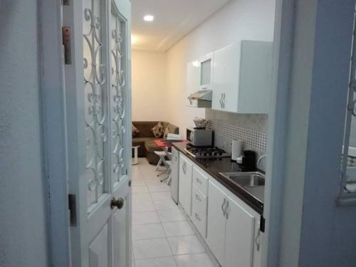 a kitchen with white cabinets and a sink at Studio en plein zone touristique avec wifi, IPTV et Clim in Sousse