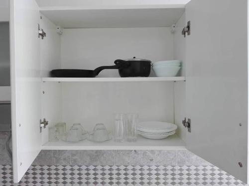 a white cabinet with bowls and dishes on it at Studio en plein zone touristique avec wifi, IPTV et Clim in Sousse