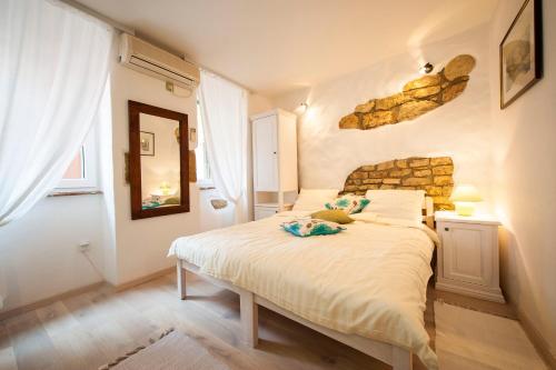 um quarto com uma cama e uma parede de pedra em Apartments Tanga em Rovinj