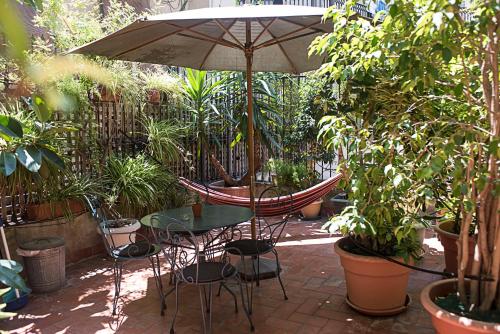 a patio with a table and an umbrella and plants at Fashion House in Barcelona