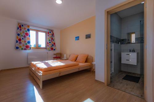 ein Schlafzimmer mit einem Bett mit orangefarbenen Kissen in der Unterkunft Včelařství pod svatým Floriánem in Znojmo