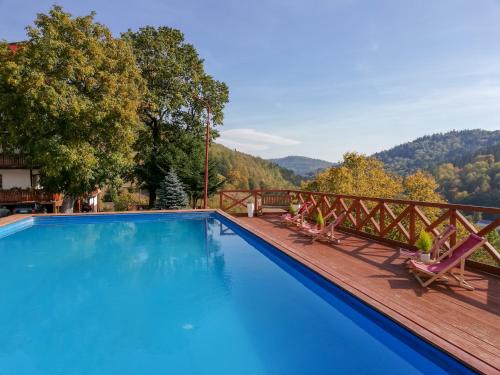 a swimming pool on a deck with a view of the mountains at Ośrodek Wypoczynkowy Pod Dębem in Wójtowice