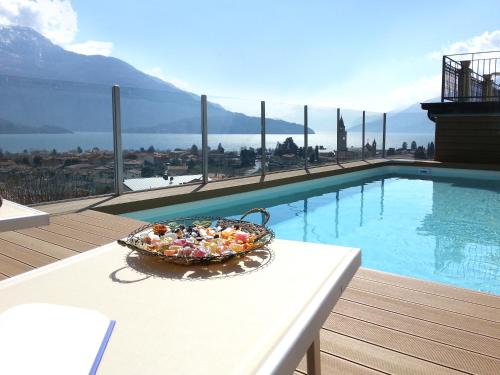 a basket of candy on a table next to a swimming pool at Villa Perla del Lago in Vercana