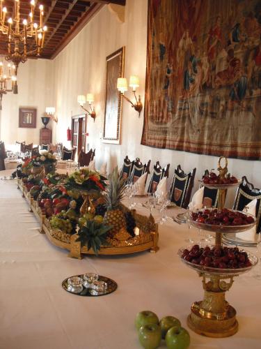 a long table with fruits and plates of food at Parador de Santiago - Hostal Reis Catolicos in Santiago de Compostela