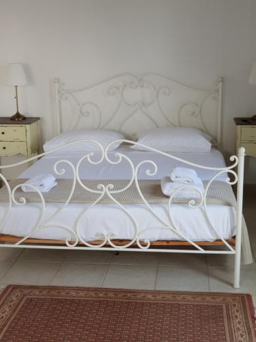 a white bed with white sheets and towels on it at Sea front Villas Danezis in Symi
