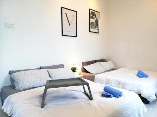a room with two beds and a table on a couch at Puchong Skypod Residence, 1-5 pax Cozy Unit, Walking Distance to IOI Mall, 10min Drive to Sunway in Puchong