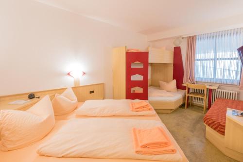 a hotel room with two beds and a bedroom at Hotel Restaurant Fallerhof in Bad Krozingen