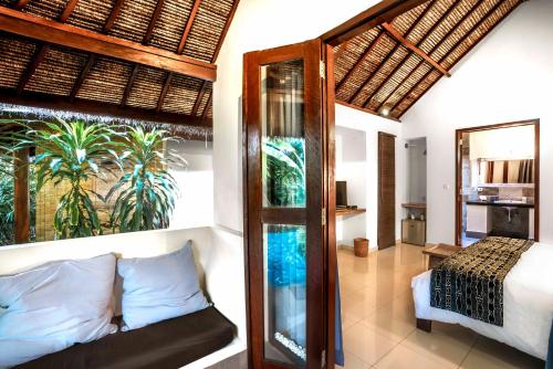 a bedroom with a bed and a room with a window at Manta Dive Gili Air Resort in Gili Islands