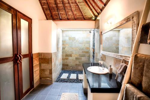 La salle de bains est pourvue d'un lavabo et d'une douche. dans l'établissement Manta Dive Gili Air Resort, à Gili Air