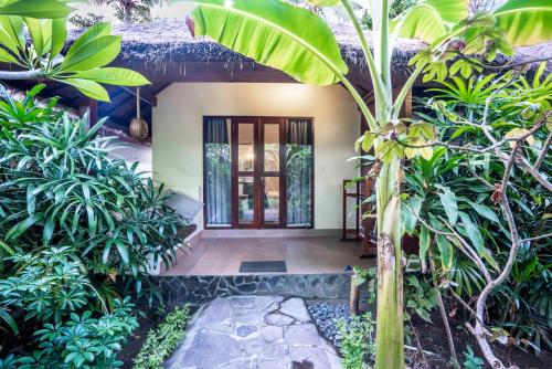a front door of a house with trees and plants at Manta Dive Gili Air Resort in Gili Islands