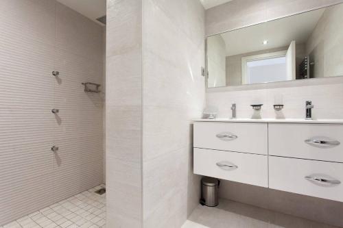 une salle de bain blanche avec un lavabo et un miroir dans l'établissement Carlton area: New 2 beds / 2 baths, à Cannes