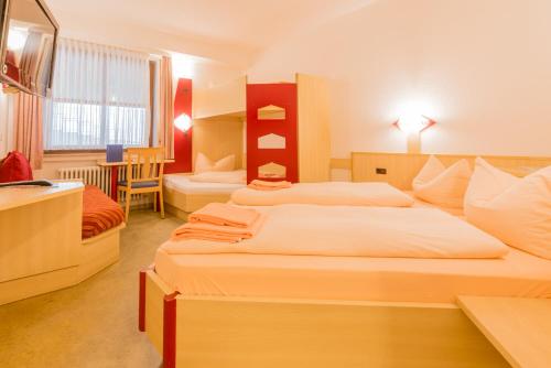 a hotel room with two beds and a kitchen at Hotel Restaurant Fallerhof in Bad Krozingen