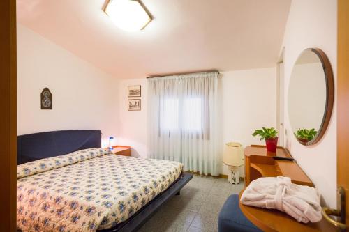 a bedroom with a bed and a desk and a mirror at Albergo Ristorante Fabrizio in Caorle