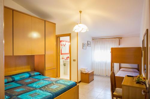 a bedroom with a bed and a table and a desk at Albergo Ristorante Fabrizio in Caorle