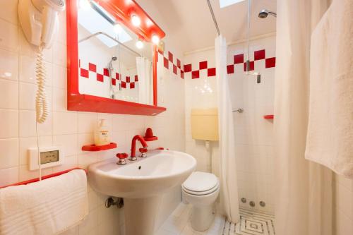 a bathroom with a sink and a toilet and a mirror at Albergo Ristorante Fabrizio in Caorle