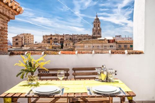 a table on a balcony with a view of a city at Feelathome Merced Apartments in Málaga