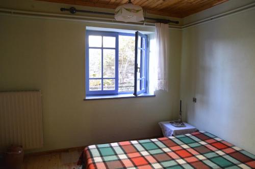 sypialnia z łóżkiem i oknem w obiekcie Petroto house w mieście Fragades