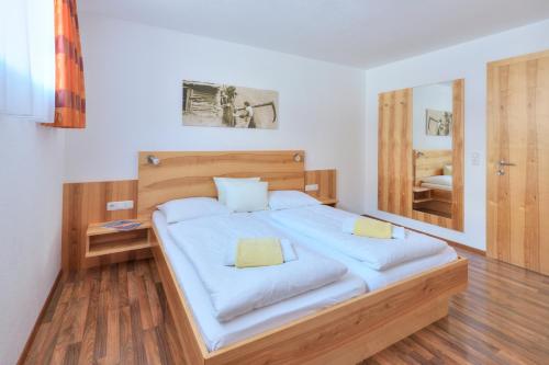 a bedroom with a large bed with a mirror at Apart Bellevue in Pettneu am Arlberg