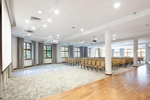 a large room with chairs and a room with wooden floors at Dolina Charlotty Resort&Spa in Słupsk