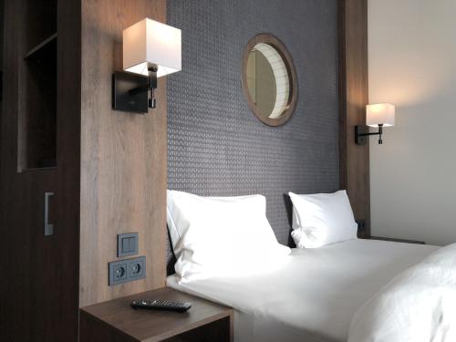 シュヴェービッシュ・ハルにあるHotel Smartinoのベッドと鏡が備わるホテルルーム