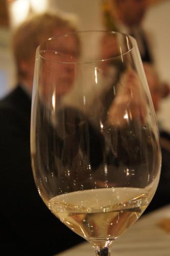 a glass of white wine sitting on a table at Pension Pernthaler in Silandro