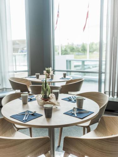 a row of tables and chairs in a restaurant at Radisson Blu Airport Hotel, Oslo Gardermoen in Gardermoen