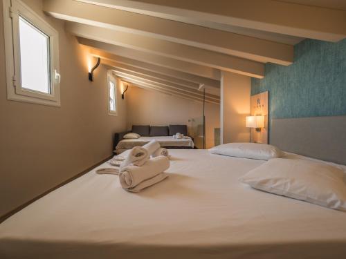 a hotel room with two beds with towels on them at Paradise Resort in Finikounta