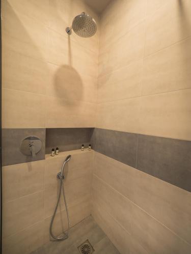 a bathroom with a shower with a shower head at Paradise Resort in Finikounta
