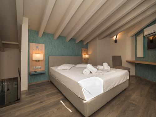 a bedroom with a bed with white sheets and pillows at Paradise Resort in Finikounta
