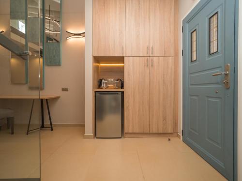 a kitchen with a blue door and a refrigerator at Paradise Resort in Finikounta