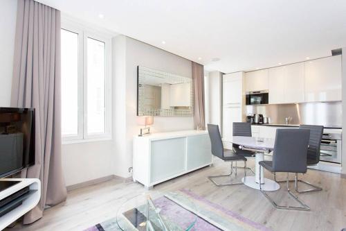 une cuisine avec une table et des chaises dans une pièce dans l'établissement 1 bedroom in front of the Palais!, à Cannes
