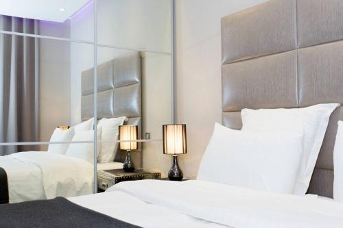 une chambre avec deux lits et un grand miroir dans l'établissement 1 bedroom in front of the Palais!, à Cannes