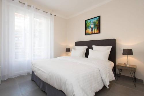 - une chambre blanche avec un grand lit et des draps blancs dans l'établissement MARRIOTT : 2 BEDS/2 BATHS SEA VIEW, à Cannes