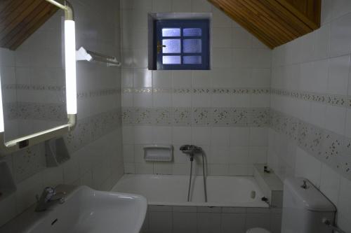 a bathroom with a bath tub and a sink at Petroto house in Fragkades