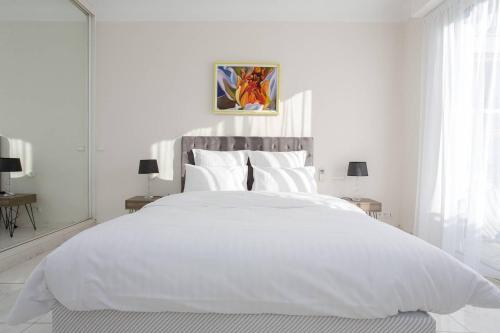 - une chambre blanche avec un grand lit blanc et des draps blancs dans l'établissement MARIOTT AREA: SUNNY 2 BEDS /2 BATHS, à Cannes