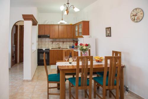Ágios MatthaíosにあるJ&B Countryside Lifeのキッチン(木製テーブル、椅子、冷蔵庫付)
