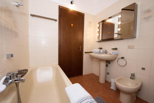 a bathroom with a tub and a sink and a toilet at Villa Margherita in Torri del Benaco